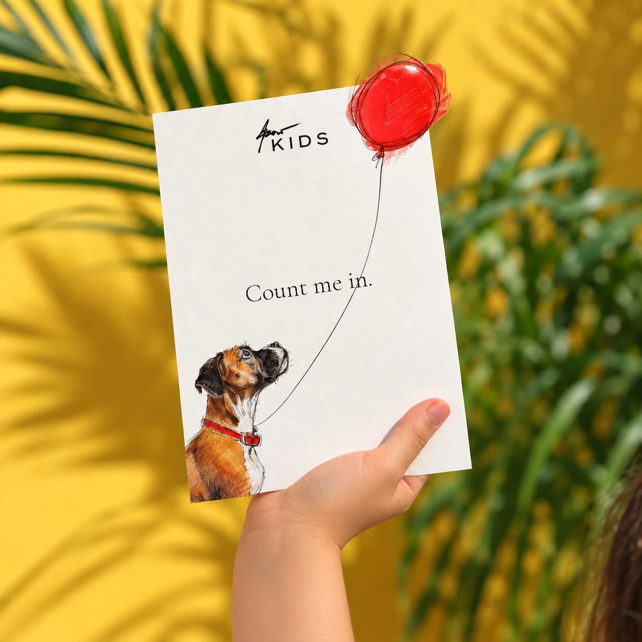A child's hand holding up the reply card: Azar Kids, count me in — the boxer looking up at the red balloon
